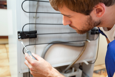 Bigstock Man During Fridge Repair 82690565